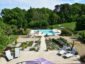 une piscine dans un jardin avec des chaises et des arbres dans l'établissement Luxurious Mansion in Aquitaine with Swimming Pool, à Port-Sainte-Foy-et-Ponchapt