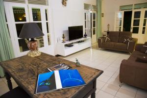 a living room with a table with a book on it at Villa Joland in Sainte-Anne