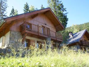 a log home with a balcony on the side of it at Mountain Chalet in Oz en Oisans with Lovely Views over Lake in Oz