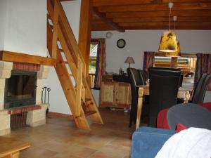 a living room with a fireplace and a wooden stairway at Mountain Chalet in Oz en Oisans with Lovely Views over Lake in Oz