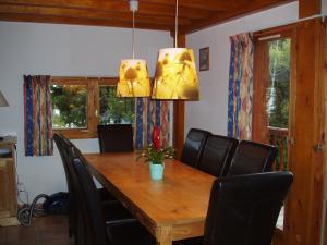 een eetkamer met een houten tafel en zwarte stoelen bij Mountain Chalet in Oz en Oisans with Lovely Views over Lake in Oz