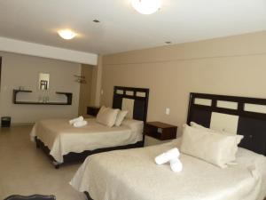 een hotelkamer met 2 bedden met witte lakens bij HOTEL GOLD in El Oro de Hidalgo