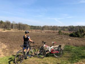 een vrouw die naast twee fietsen staat in een veld bij Wildenborcherhof in Vorden