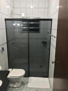 a bathroom with a glass shower with a toilet at Bravo City Hotel Nova Mutum in Nova Mutum