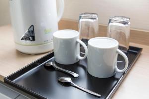 two cups and spoons on a tray on a counter at FLEXSTAY INN Shinagawa in Tokyo