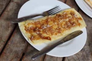 a piece of food on a white plate with a fork and knife at Alamanda Accomodation in Ubud