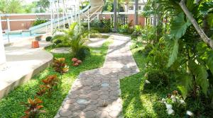 un jardín con una pasarela de piedra en un patio en Good Houses Apartment, en Bangkok