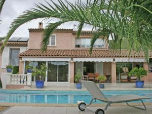 a chair in front of a house with a swimming pool at Luxurious Holiday Home in Saint Rapha l with Jacuzzi in Saint-Raphaël