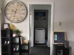 a large clock on a wall next to a room at Comfortable Home Close to Airport in Christchurch