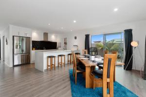 a kitchen and dining room with a table and chairs at Kihi Retreat - Ruakaka Holiday Home in Ruakaka