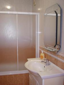 La salle de bains est pourvue d'un lavabo et d'une douche avec un miroir. dans l'établissement 2Bed 15km Lisbon - Wifi, Ac, Parking, à Arsena