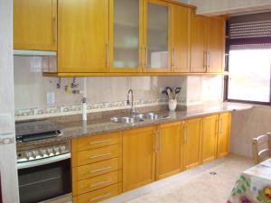 una cucina con mobili in legno e un lavello di 2Bed 15km Lisbon - Wifi, Ac, Parking a Arsena