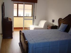 a bedroom with a bed and a chair and a window at 2Bed 15km Lisbon - Wifi, Ac, Parking in Arsena
