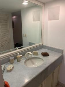 a bathroom counter with a sink and a mirror at Torre Condomar Beside Sunscape in Puerto Vallarta