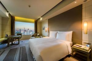 een hotelkamer met een bed, een bureau en een raam bij Hotel Nikko Saigon in Ho Chi Minh-stad