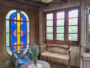 Zimmer mit zwei Buntglasfenstern und einem Tisch in der Unterkunft Octogono Om Shanti in Villa Serrana