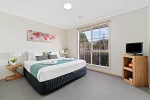 a bedroom with a large bed and a window at Park Avenue - IKON Glen Waverley in Glen Waverley