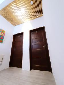 due porte marroni in una stanza bianca con soffitto di Love Travel Guest House a Città di Taitung