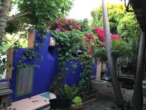 een blauwe muur met bloemen en planten erop bij Les Artistes Inn in San Diego