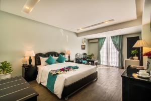 um quarto com uma cama grande e almofadas azuis em The Sunriver Boutique Hotel Hue em Hue