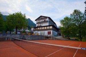 a tennis court in front of a building at Hotel Migliorati in Castione della Presolana