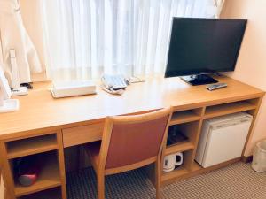 a desk with a computer monitor on top of it at Kadoya Hotel in Tokyo