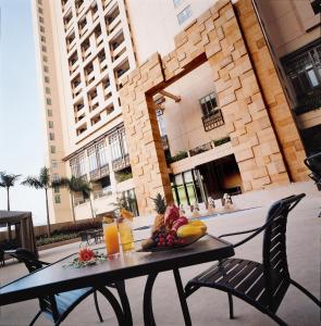 a table with fruit on it in front of a building at Rambler Oasis Hotel in Hong Kong