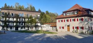 un bâtiment à côté d'un bâtiment avec un arbre dans l'établissement Waldhotel Rainau, à Ellwangen