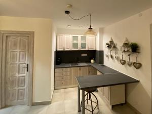 a kitchen with white cabinets and a black counter top at Penzión Vila Petra Bed&Breakfast in Veľký Slavkov