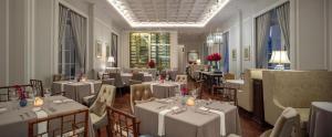 a dining room with white tables and chairs at Mia Saigon – Luxury Boutique Hotel in Ho Chi Minh City
