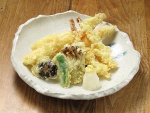 a white plate of food on a wooden table at Kadoya Hotel in Tokyo