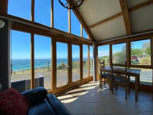 een woonkamer met een tafel en uitzicht op de oceaan bij Beautiful Wales in Barmouth