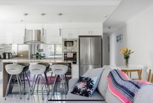 a kitchen and living room with a couch and a counter at Beachside Beauty at Burleigh Pavilion! in Gold Coast