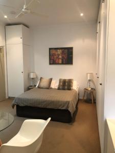 Un dormitorio con una cama, una mesa y una silla. en Hotel 59 Sydney, en Sídney