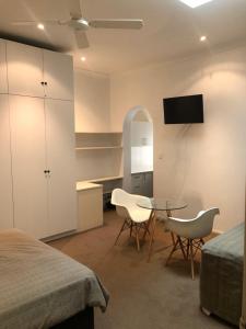 1 dormitorio con mesa, sillas y TV en Hotel 59 Sydney, en Sídney
