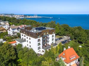 an aerial view of a building on a hill next to the water at Hotel Różany Gaj in Gdynia