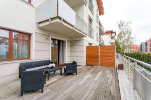 a balcony with a table and chairs on a building at Vanilla Rentyear Apartments in Gdańsk