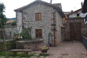 une maison en pierre avec un banc devant elle dans l'établissement La Casita Del Rincón Del Vino, à Ezcaray