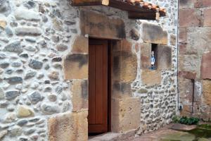 un edificio in pietra con una porta di legno di La Casita Del Rincón Del Vino a Ezcaray