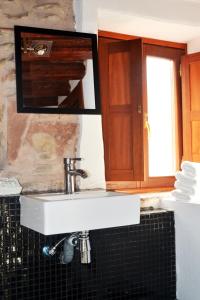 um lavatório branco na casa de banho com um espelho em La Casita Del Rincón Del Vino em Ezcaray