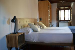 ein Schlafzimmer mit einem großen Bett mit weißer Bettwäsche und Kissen in der Unterkunft La Casita Del Rincón Del Vino in Ezcaray