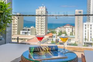 two glasses on a table with a view of a city at Platinum Danang Hotel in Da Nang