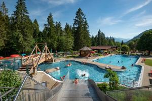 a pool at a resort with people in it at Biobauernhof und Ferienhaus Riederbauer in Rettenschöss
