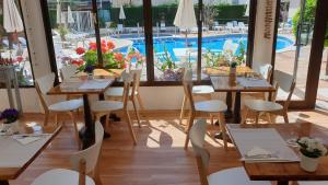 a restaurant with tables and chairs and a swimming pool at Hotel Mireia in Lloret de Mar