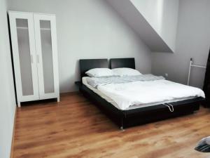 1 dormitorio con 1 cama y suelo de madera en Domek w dolinie en Berest