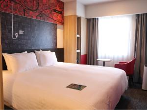 Postel nebo postele na pokoji v ubytování ibis Osaka Umeda
