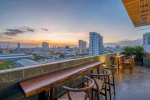 une rangée de tabourets de bar sur un toit surplombant une ville dans l'établissement Platinum Danang Hotel, à Đà Nẵng