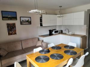 a kitchen and living room with a wooden table and chairs at U Lotnika in Szlachtowa