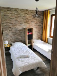 a bedroom with two beds and a brick wall at U Lotnika in Szlachtowa