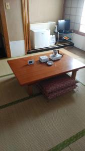 - Mesa de centro de madera en una habitación con espejo en Takasaki Ekimae Plaza Hotel en Takasaki